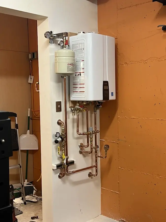 Plumbing technician inspecting water heater connections in Highlands